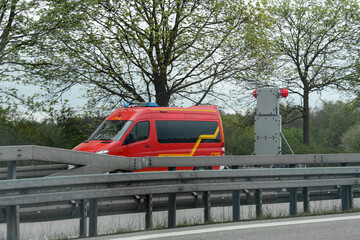 Emergency vehicle on the highway responding to an incident in a rural area during overcast weather