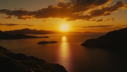 Golden sunset over tranquil ocean and islands. Silhouette mountains frame the scene