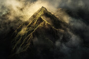 Majestic mountain peak piercing through dramatic clouds. Lush green slopes emerge from a sea of mist and shadows, bathed in golden light from above