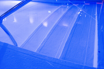 Obraz premium A modern swimming pool illuminated with purple lights, offering a tranquil nighttime setting.