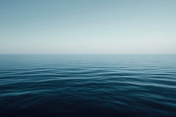 Fototapeta premium Serene expanse of placid ocean. Gentle waves meet a clear, pale sky
