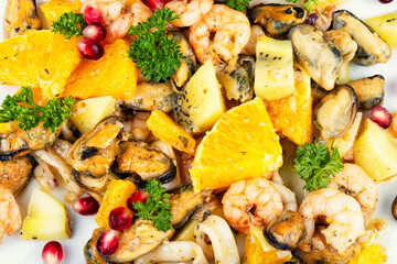 Plate of delicious fruit salad with seafood.