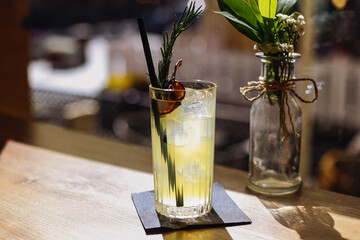 Yellow cocktail drink. Fresh citrus mix. Ice glass with herbs. Bar sunlight elegant drink scene. Refreshing moment. Summer beverage idea. Tasty drink shot. Chill atmosphere. Summer vibe background.