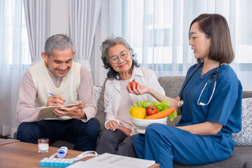 home health care nurse in uniform explaining nutritional value of fruits,vitamins and dietary fiber to senior couple,old man writing on notebook