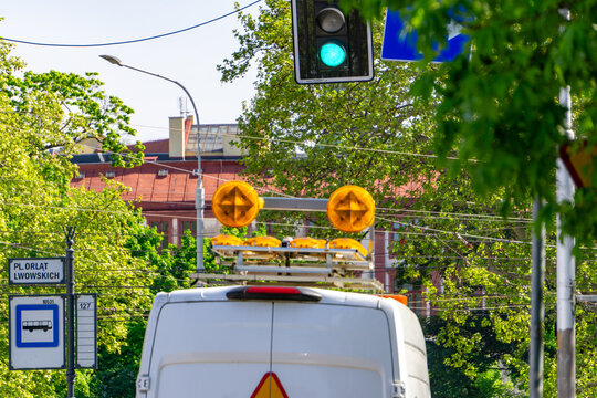 A service vehicle in front of traffic lights at the bus stop on Płk. Orląt Lwowskich Street in Wrocław on a sunny day.