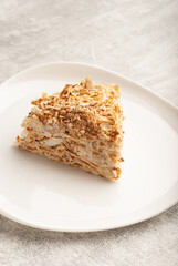 A slice of rich, layered dessert low calorie napoleon cake is presented on a floral plate alongside...