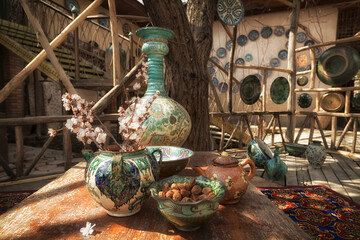Uzbek traditional dishes, a branch of flowering almonds and a dish with dried apricots in the yard