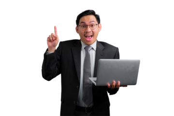 Excited young Asian businessman pointing up while holding laptop isolated on transparent background