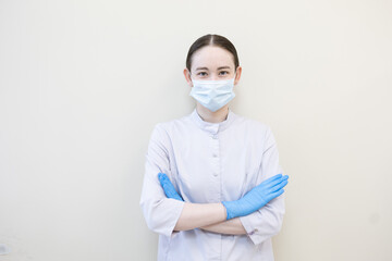 Doctor in white coat, mask and gloves. Young female doctor