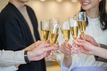 仲間たちがグラスを合わせて乾杯する楽しいひとときのクローズアップ