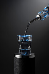 Vodka pouring from the bottle into a glass on a dark background.