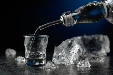 Crystal clear vodka or gin being poured into a glass.