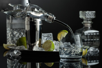 Vodka is poured into a glass with ice.
