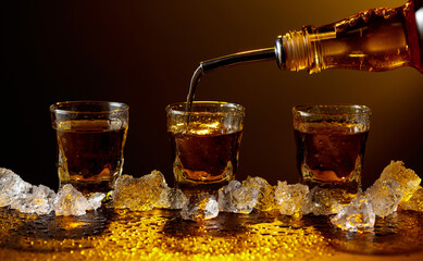 Whiskey pours from bottle to glass.