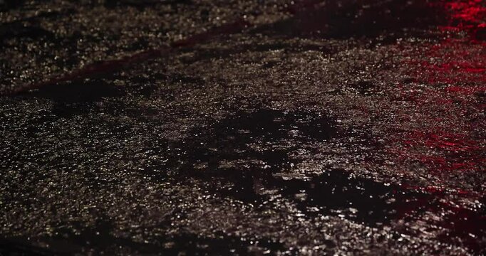 A slow motion of raindrop on the city street at night
