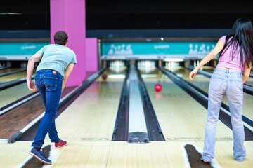 Friends playing bowling together in modern alley