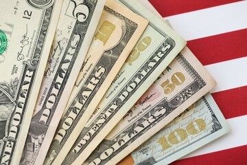 American US dollars money bills and on American flag close up
