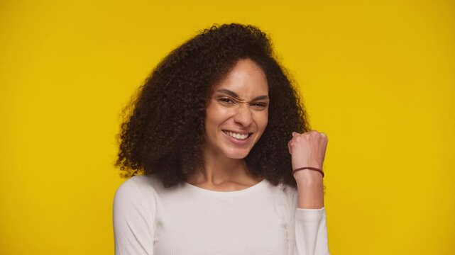 Excited young woman celebrating success with fist pump