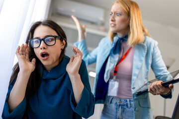Woman yelling at a colleague in an office, showing workplace bullying.