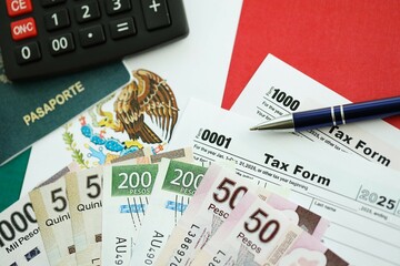 Mexican pesos money bills in big amount lies on table with pen, calculator, passport and tax forms