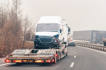 Highway tow truck hauling wrecked van