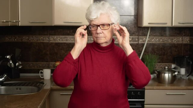 Tired elderly woman puts on and takes off glasses. Old woman wears corrective glasses for nearsightedness and farsightedness. Senior people with poor vision. Care for elderly persons medicine and