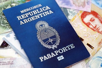 Argentine passport lies on Argentina pesos money bills close up. Travel and citizenship
