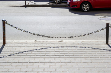 Paved brick road. Old road barriers from chain and car. Photography. Background. Kyiv, Ukraine