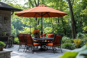 Obraz premium Patio dining set with umbrella, metal-framed chairs, and orange cushions on a bar table. Outdoor furniture for modern relaxation.