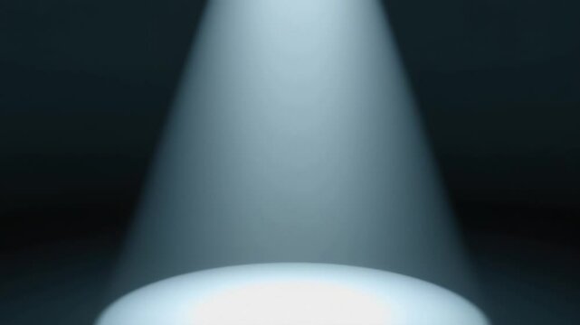 A solitary spotlight cuts through the darkness, illuminating a circular patch on an empty stage, symbolizing focus, importance, revelation, or the anticipation of a performance.
