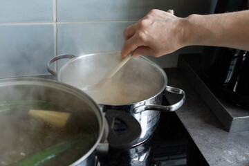 Cooking in the Kitchen Skillfully Stirring a Pot on a Hot Stove to Create Delicious Meals