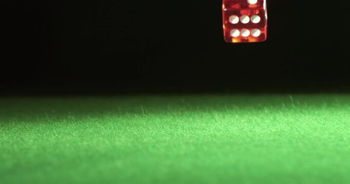 Red dice falling and bouncing on green table on a dark background. Shot on super slow motion camera 1000 fps. - Powered by Adobe