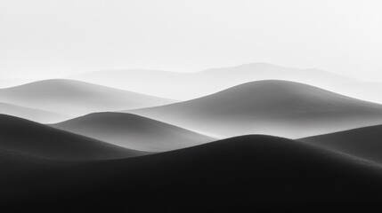 Monochrome landscape of rolling sand dunes in soft light and shadows.