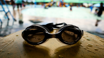 Black swimming goggles with water droplets