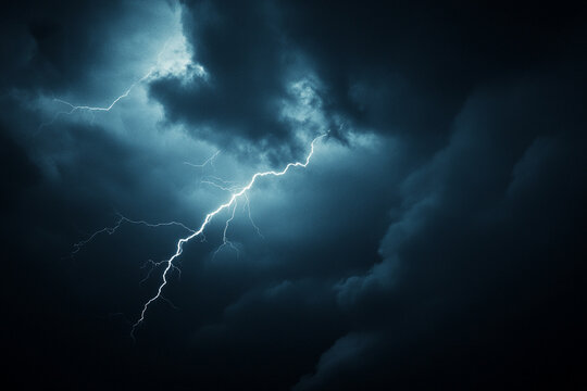 Intense lightning strikes during a nighttime thunderstorm with dark clouds looming overhead