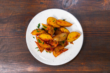Crispy roasted potatoes with herbs served on a white plate