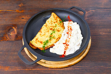 Delicious dish served in a pan with yogurt and spices