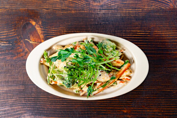 Delicious vegetable dish with herbs on a wooden table