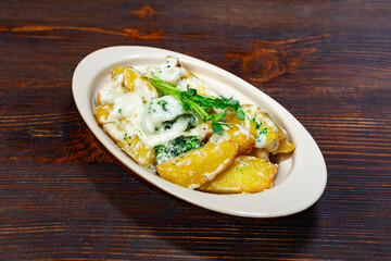 Creamy vegetable and potato dish served on wooden table