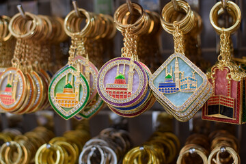 Colorful Islamic key chains are displayed, featuring iconic illustrations of the Prophet's Mosque...