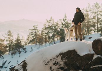 A man and his dog at the top of a mountain