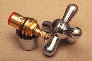Chrome faucet handle and brass valve cartridge. The plumbing repair parts.