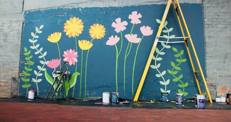 Creative, ladder and painting with mural on wall on street for decoration, improvement or renovation. Background, DIY and flowers outdoor for community art project, design or neighborhood upliftment