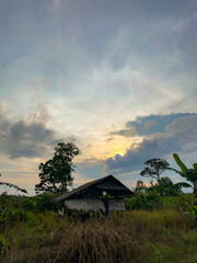 Traditional Wooden Hut in Tropical Countryside at Sunset