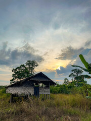 Tropical Village Landscape with Wooden House and Sunset Clouds
