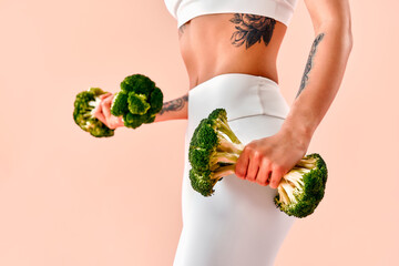 An unrecognizable image of a fit and athletic girl in white fitness clothing with a tattoo on her...