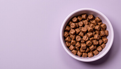 Fototapeta premium Delicious chocolate candies in white bowl on soft purple background, perfect for sharing or enjoying as treat