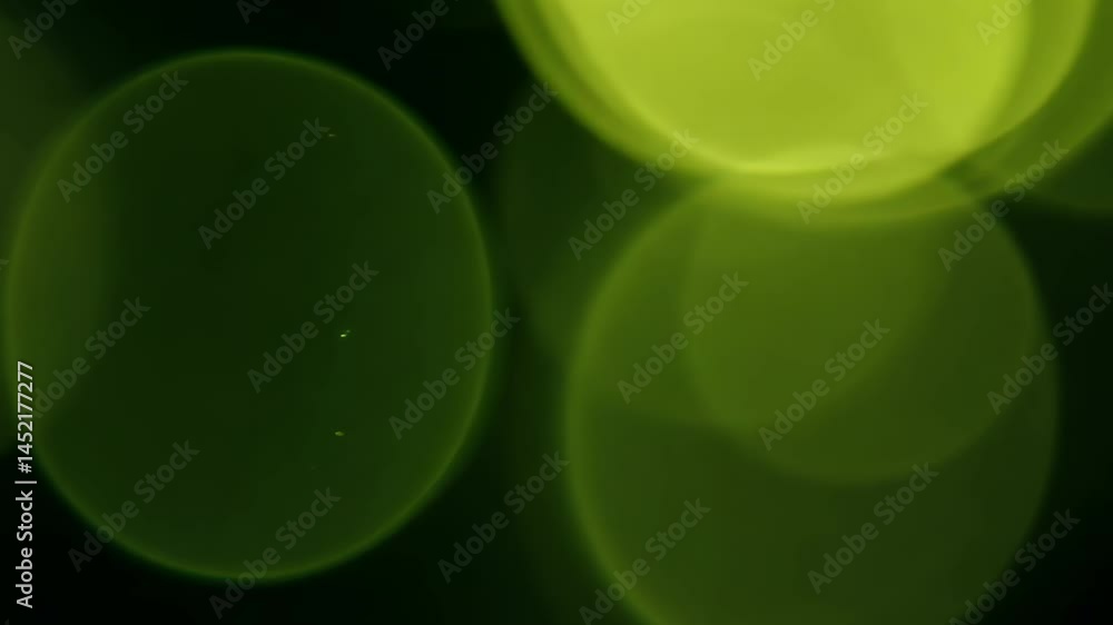 Poster this abstract image features glowing green circles on a dark background, creating a soft and dreamy 