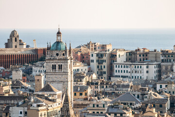 Obraz premium View of Genoa's rooftops at sunset, showcasing the city’s historic skyline and warm golden light.