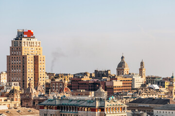 View of Genoa's rooftops at sunset, showcasing the city’s historic skyline and warm golden light.